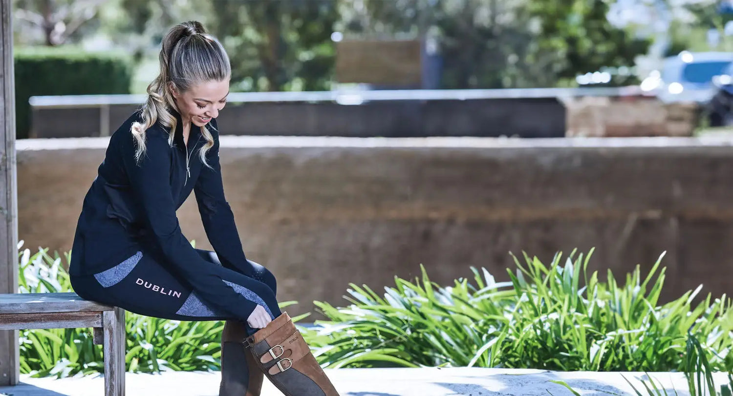 Woman in athletic wear adjusting her shoe, showcasing Weatherbeeta Victoria style.