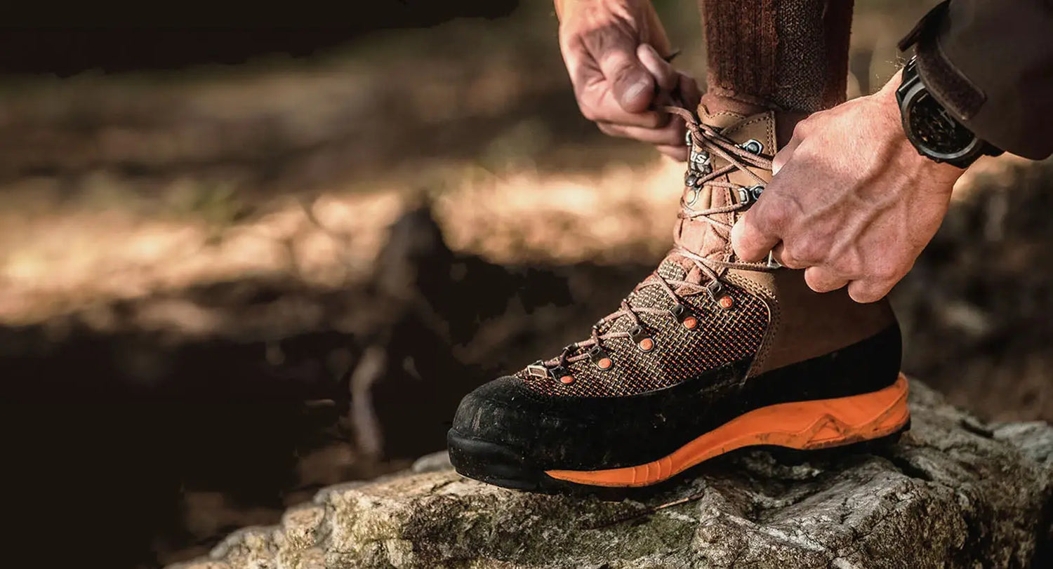 Hiking boot laced up on rocky surface, showcasing Crispi’s outdoor gear made from sustainable materials.