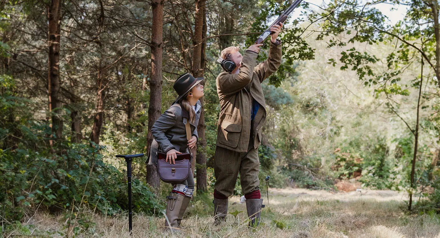 Two people in old-fashioned forest clothing for the shooting season outfit guide