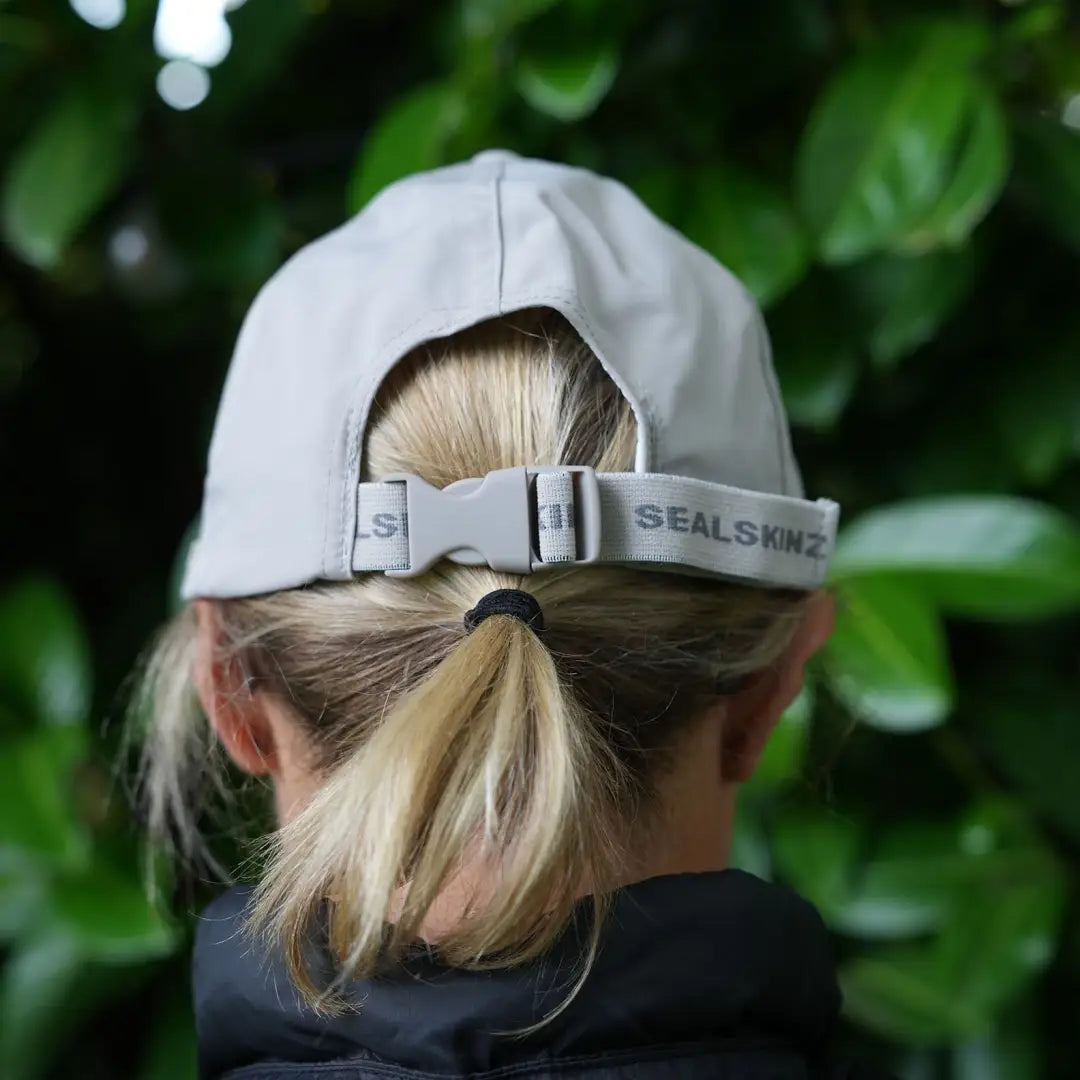 Light gray Sealskinz Salle Cap with adjustable strap, stylishly worn backwards