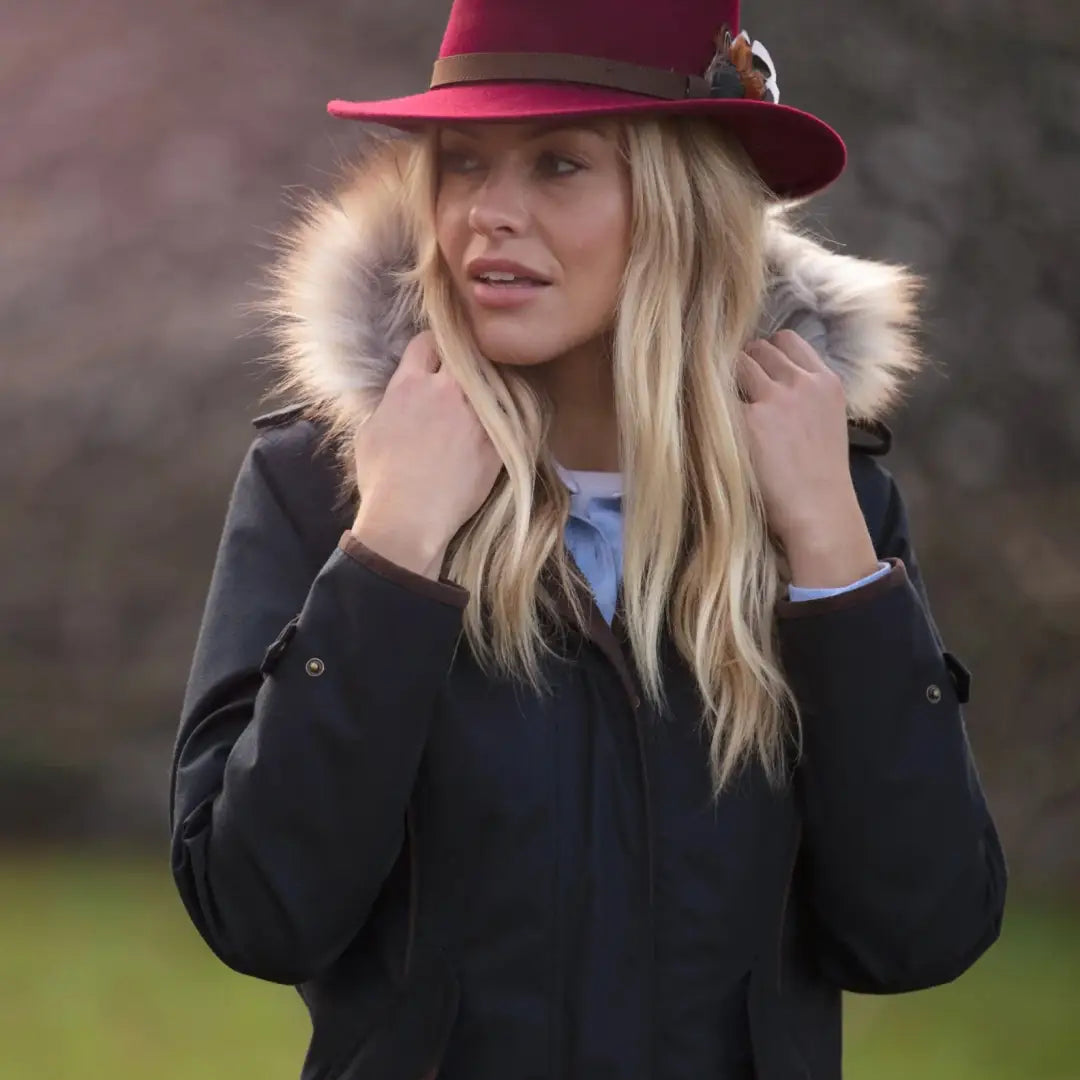 Woman in a pink fedora and dark fur-trimmed coat, showcasing Alan Paine Fernley style