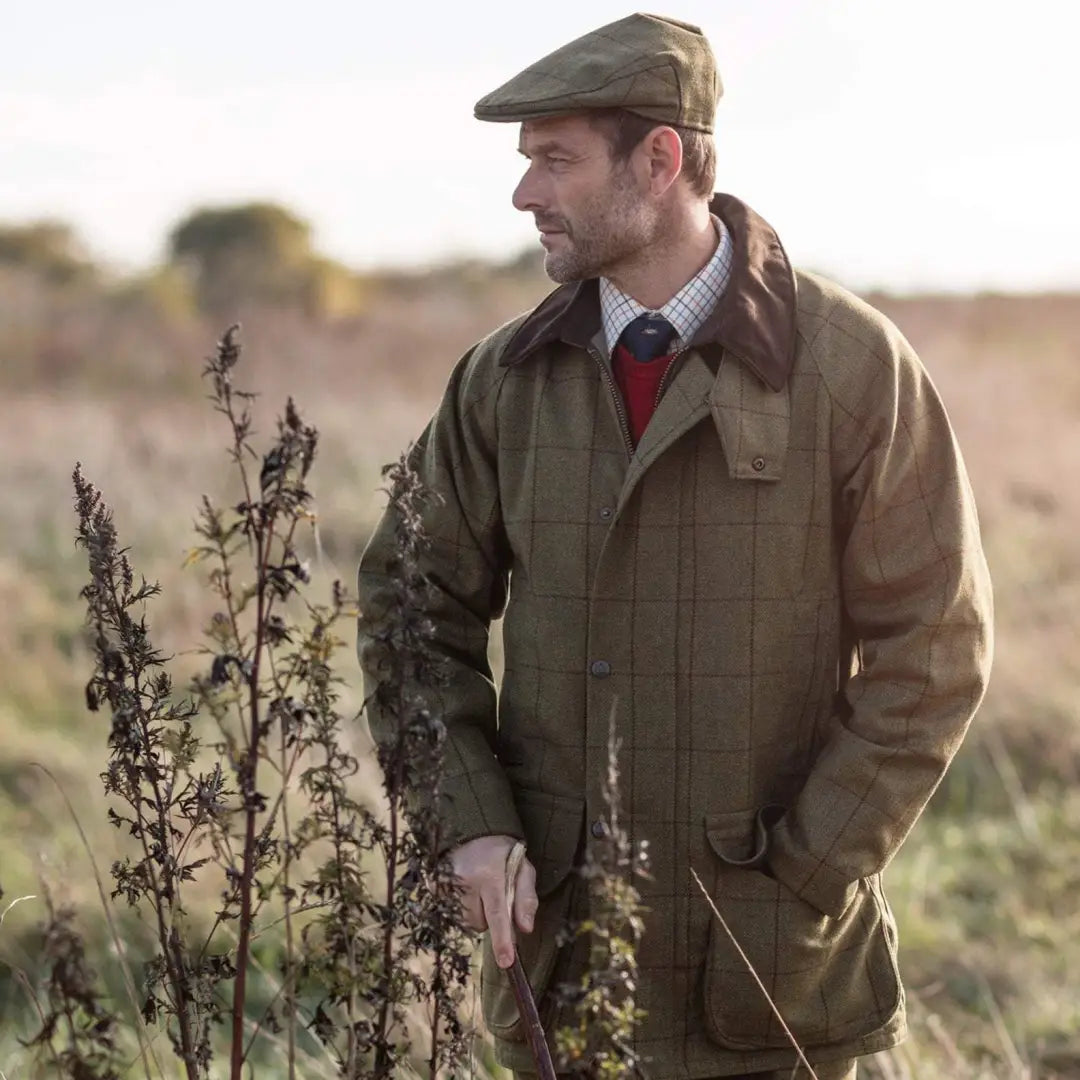 Man in a flat cap and jacket in a field, showcasing Alan Paine Rutland style