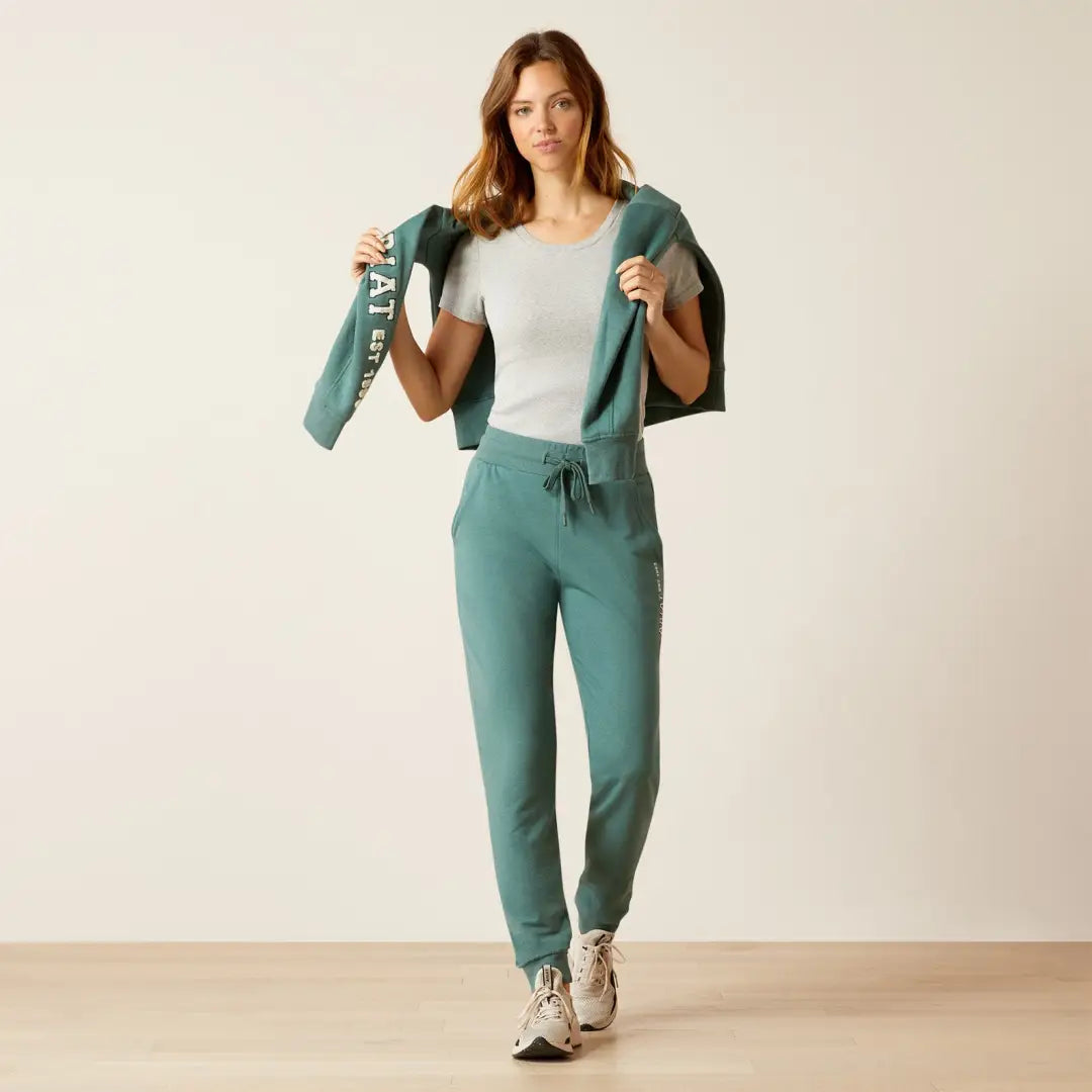 Woman in a teal Ariat Memento Jogger tracksuit, perfect for country clothing and hunting