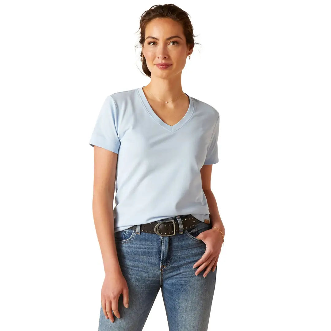 Woman in a light blue V-neck T-shirt and jeans, perfect for country clothing and outdoors