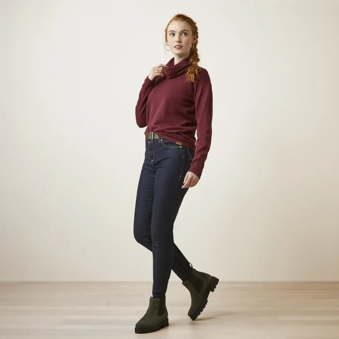 Young woman in a burgundy sweater and jeans, rocking stylish country clothing outdoors