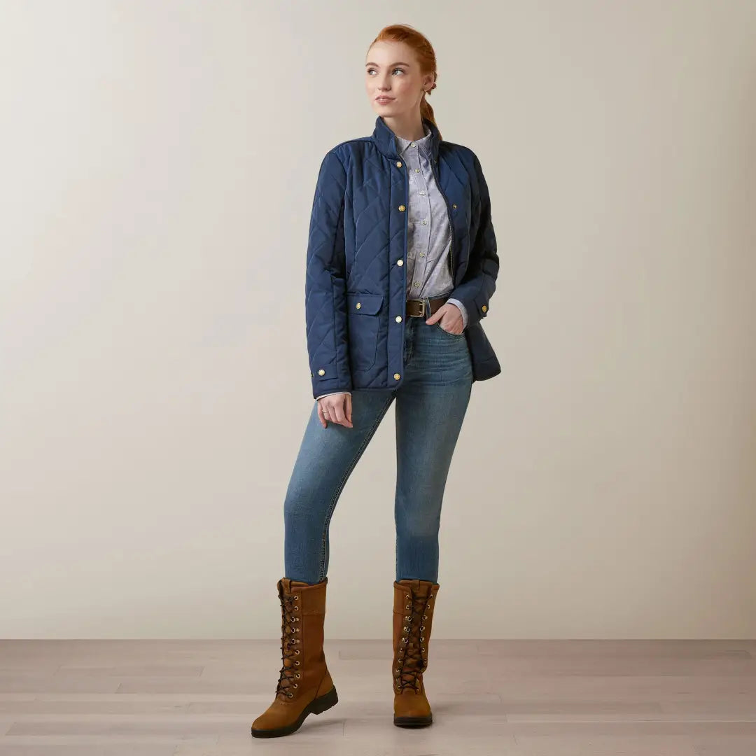 Woman in navy blue Ariat Womens Woodside Jacket with timeless quilted silhouette and jeans