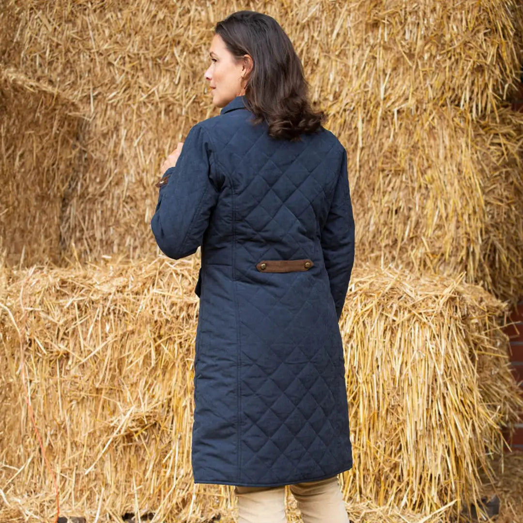 Navy blue diamond quilted coat with a stylish brown leather belt detail at the back