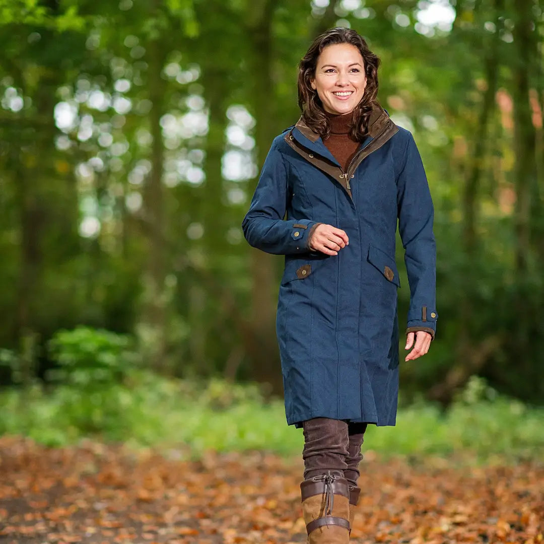 Woman in a blue Baleno Chelsea coat strolling through an autumn forest