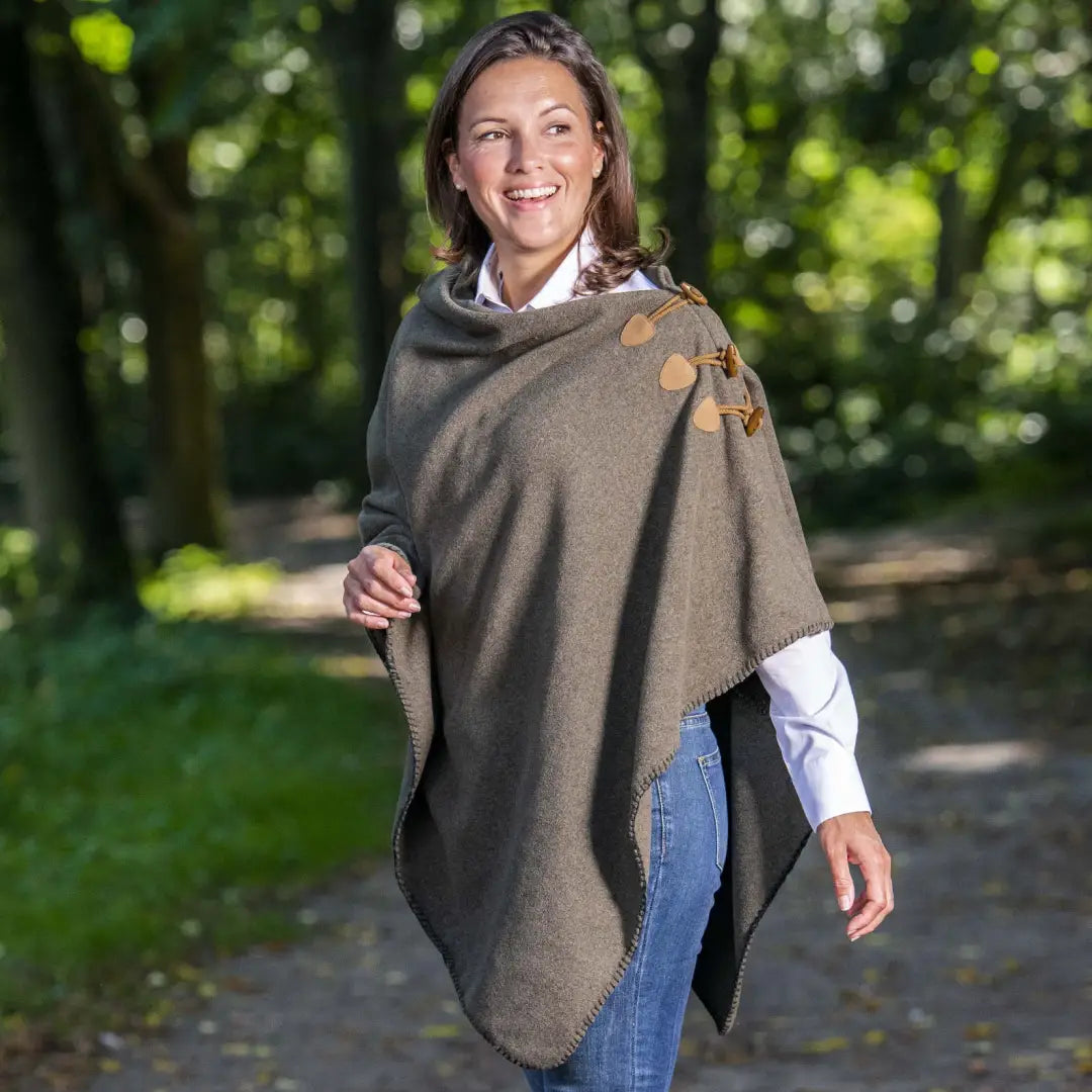 Smiling woman in Baleno Elite Fleece Poncho with leaf embroidery in olive green