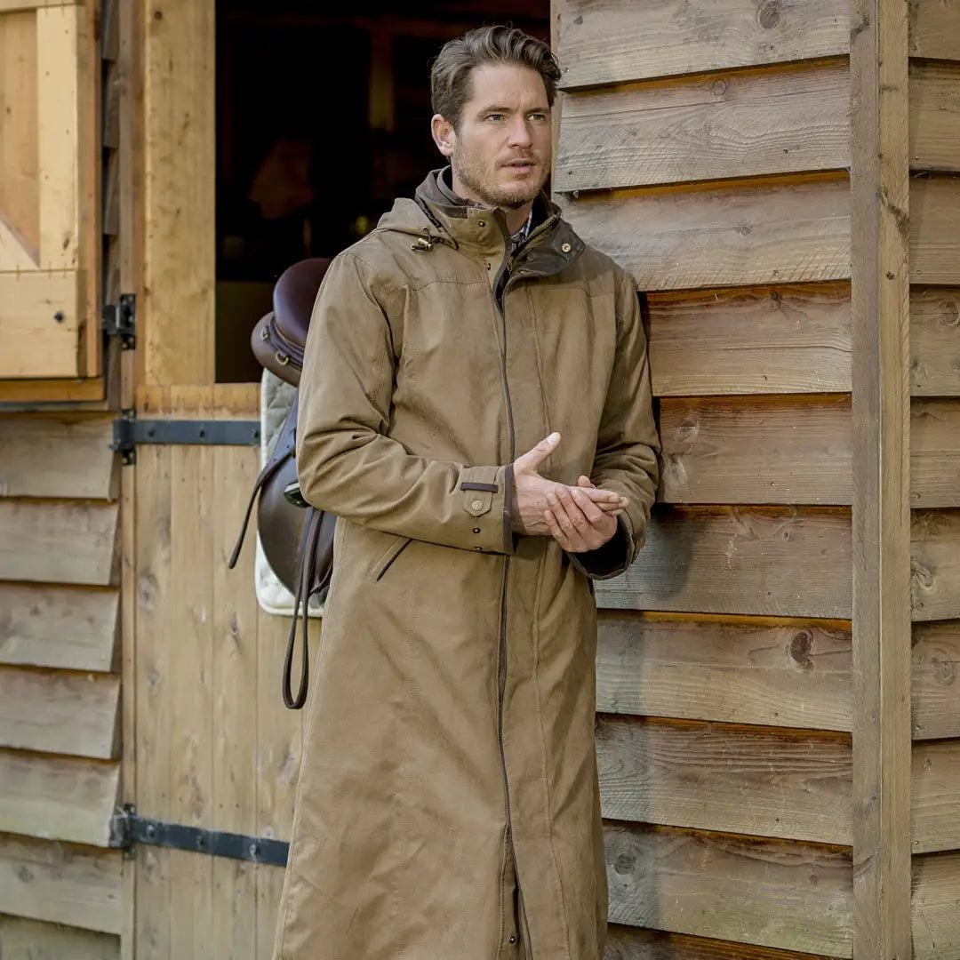 Man in a Baleno Livingstone Men’s Drovers Coat by a wooden structure in the outback