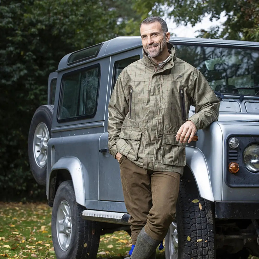 Land Rover Defender and Baleno Moorland Mens waterproof jacket in rugged outdoor setting