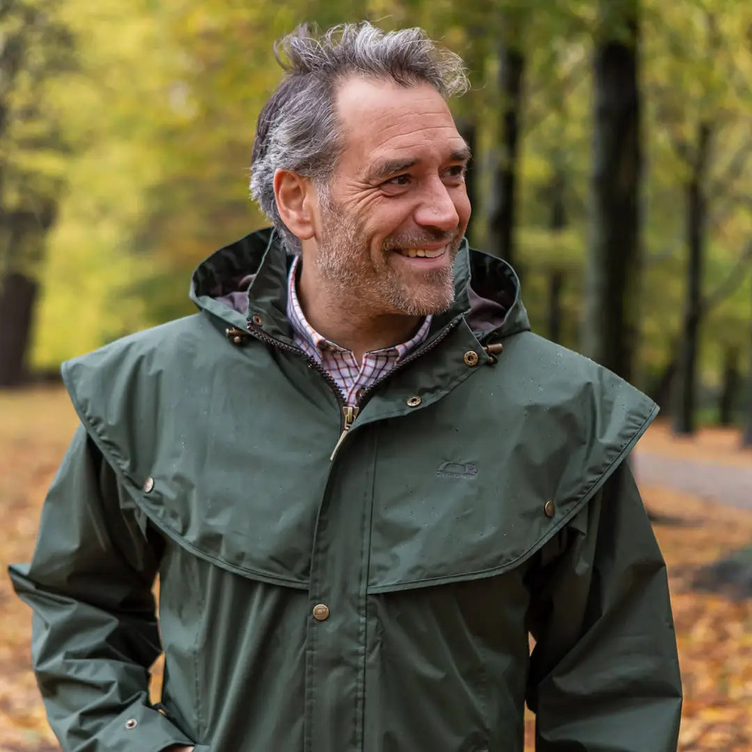 Smiling man in green Baleno Newbury Mens Full Length Coat in autumn scenery