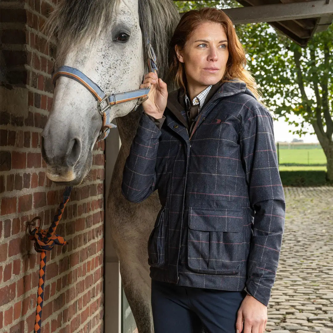 White horse with blue halter next to person in Baleno Pembroke Ladies Waterproof Jacket