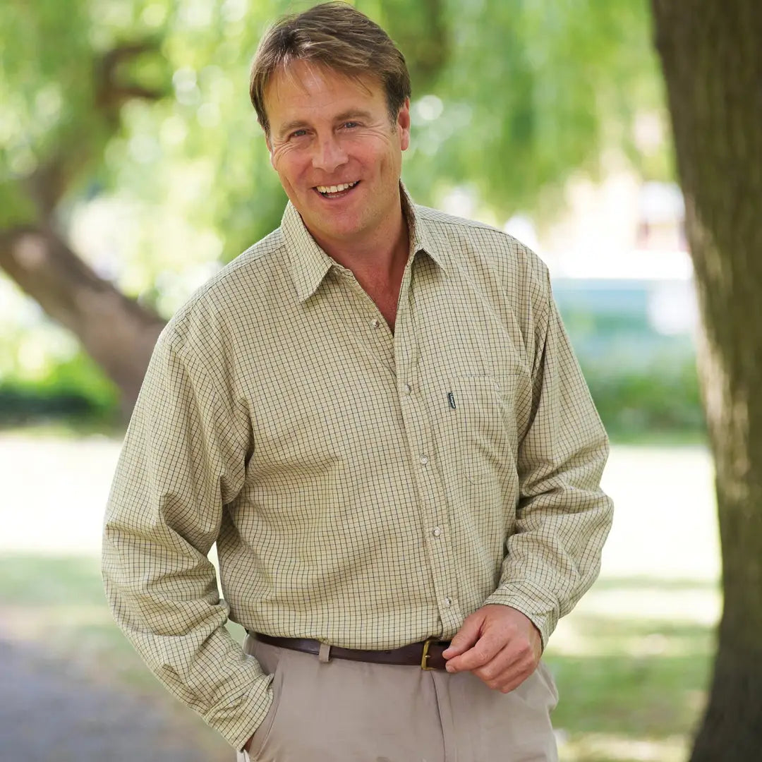 Smiling man in a beige checkered Champion Cartmel fleece lined shirt outdoors