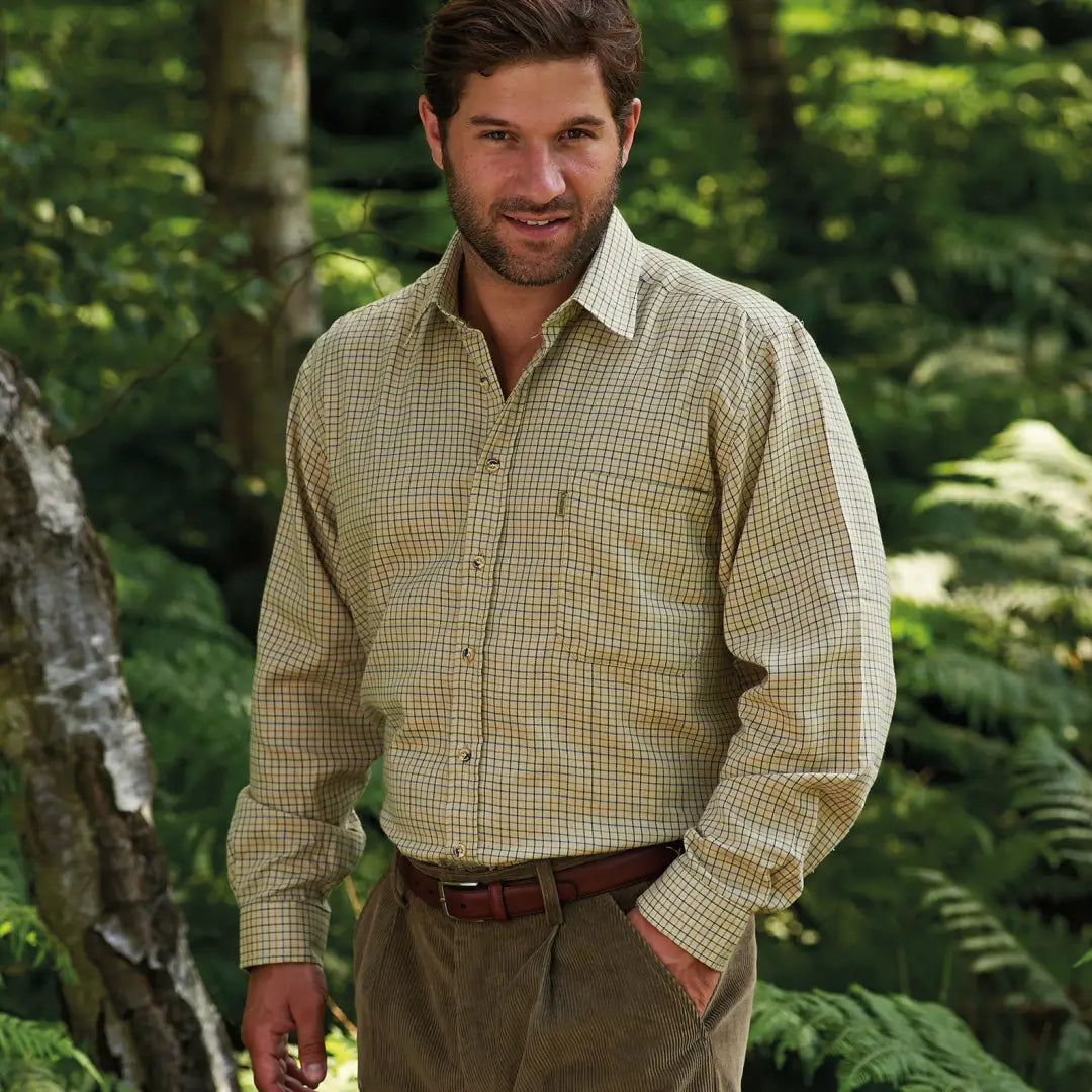 Man in a checkered Champion Cartmel long sleeve country shirt in a forest setting