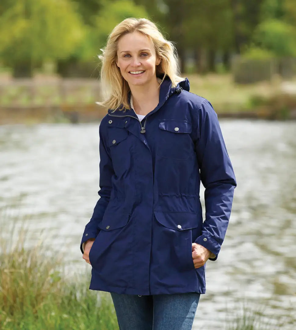 Smiling woman models Champion Filey Ladies Waterproof Coat in navy blue with pockets