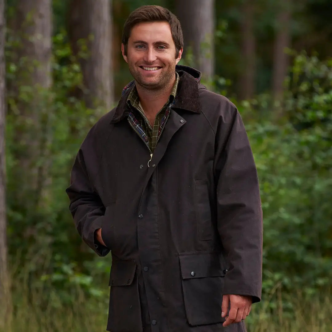 Smiling man in a Champion Howick Wax Jacket outdoors, showcasing style and comfort