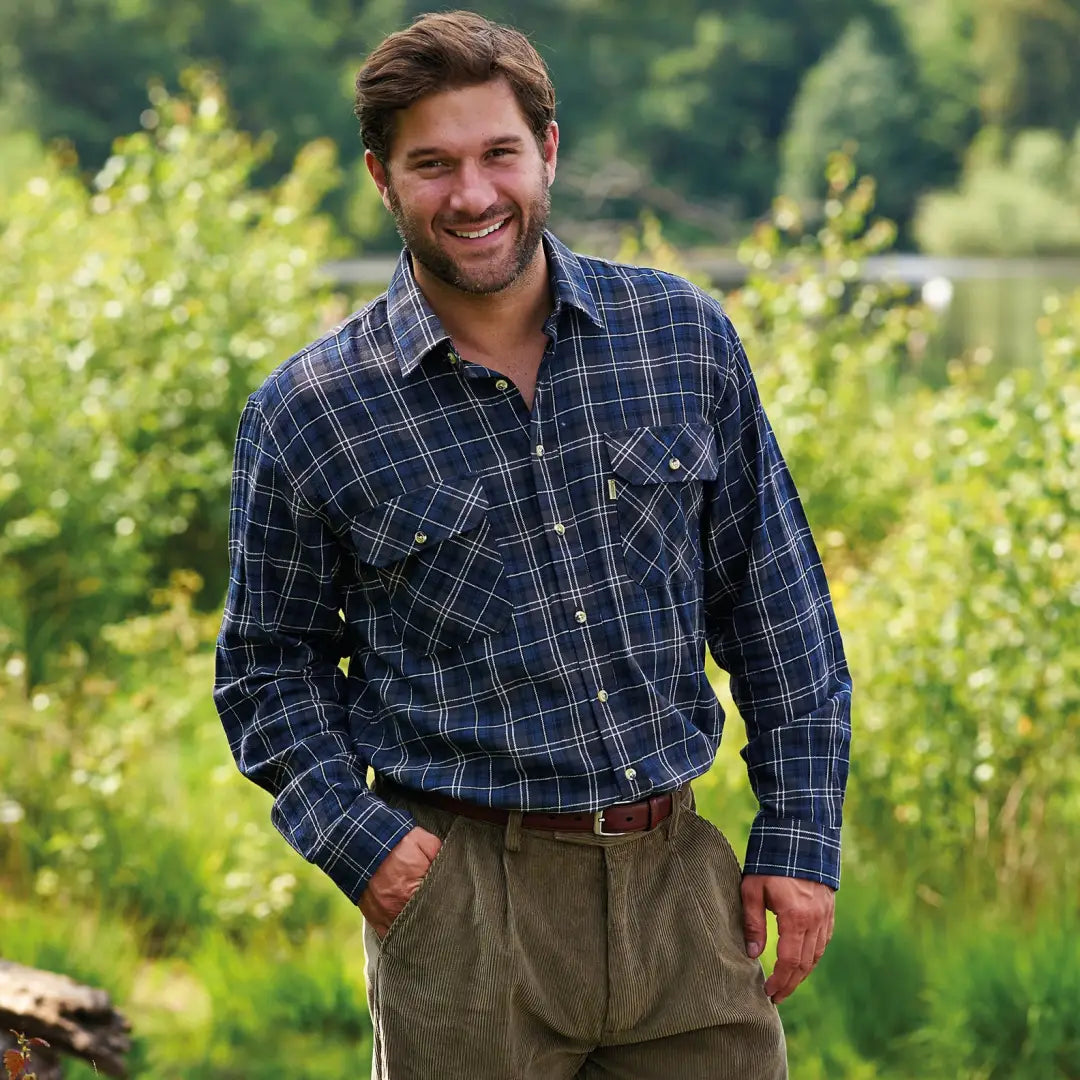 Smiling man in outdoor setting wearing a Champion Kilbeggan Shirt and brown pants