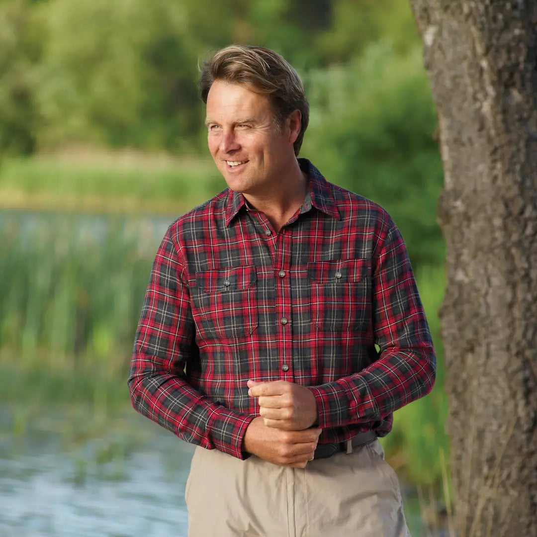 Man in a red plaid flannel wearing a Champion Kilbeggan Shirt outdoors