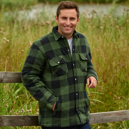 Smiling man wearing a Champion Kinross padded shirt in green and black checkered flannel