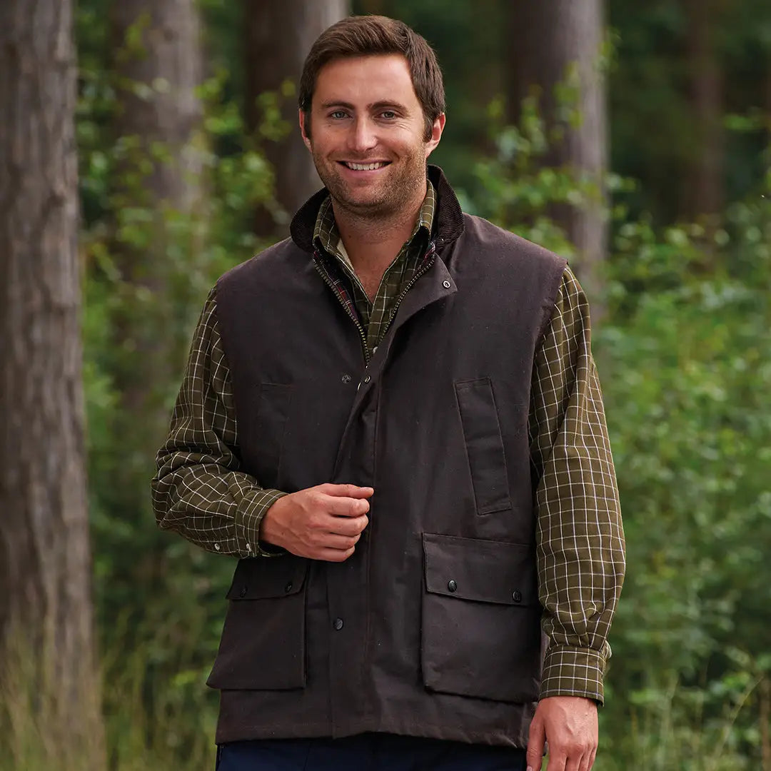 Man in a dark vest over plaid shirt rocks the Champion Lanark Wax Bodywarmer outdoors