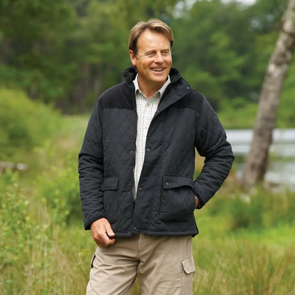 Man in a dark jacket and khaki pants rocking the Champion Lewis Quilted Jacket outdoors