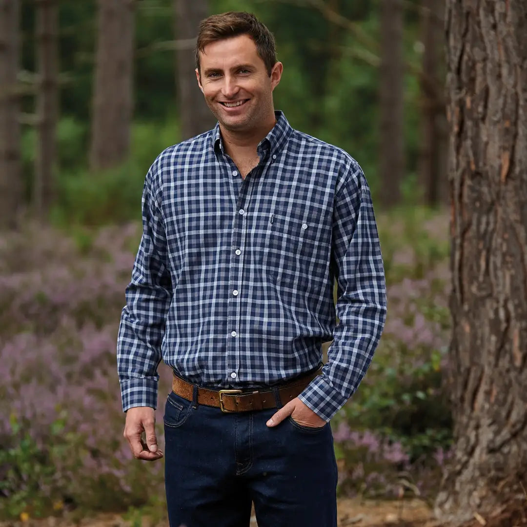 Man in a Champion Southwold Long Sleeved Shirt and jeans in a forest setting