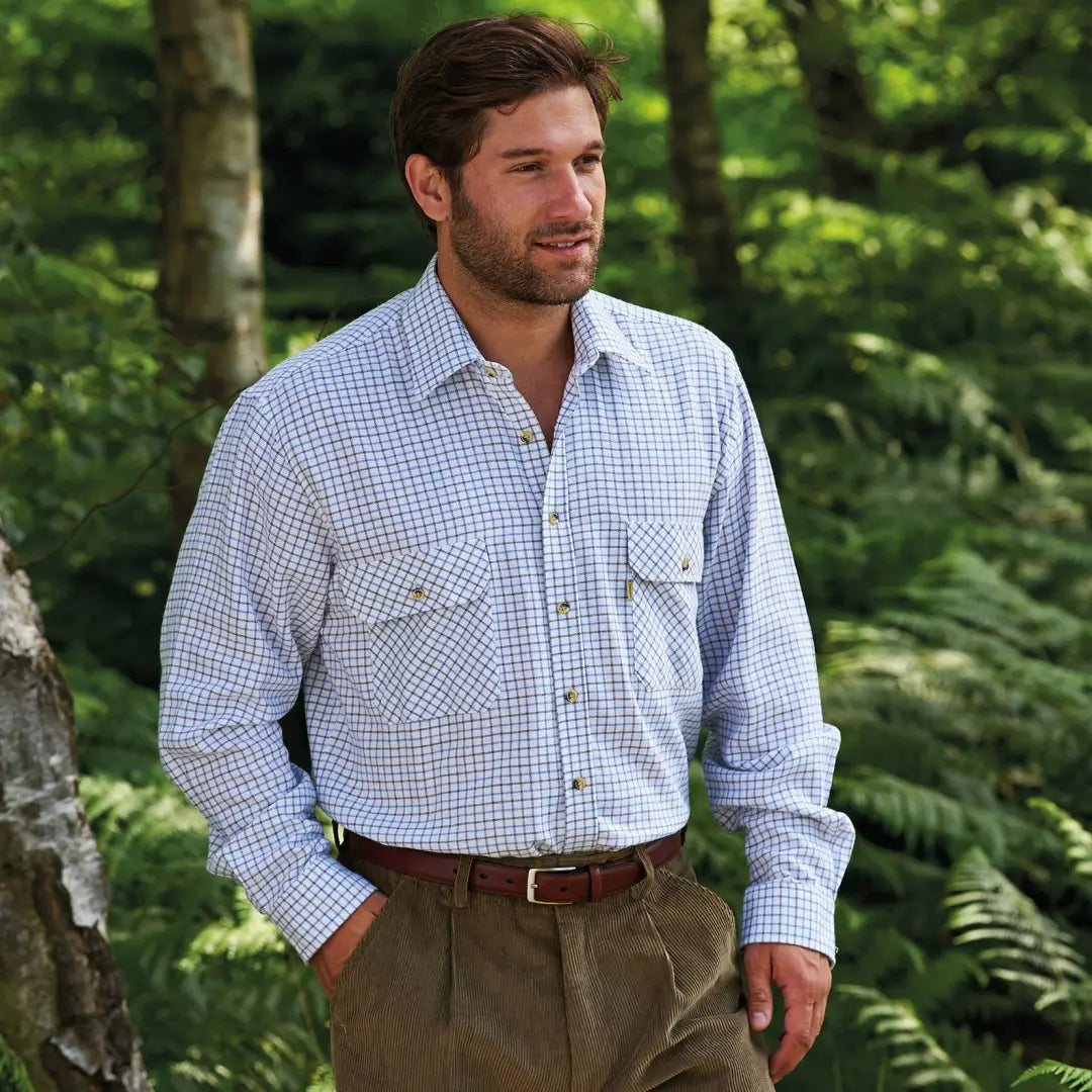 Man in a checkered Champion Tattersall Shirt and khaki pants outdoors