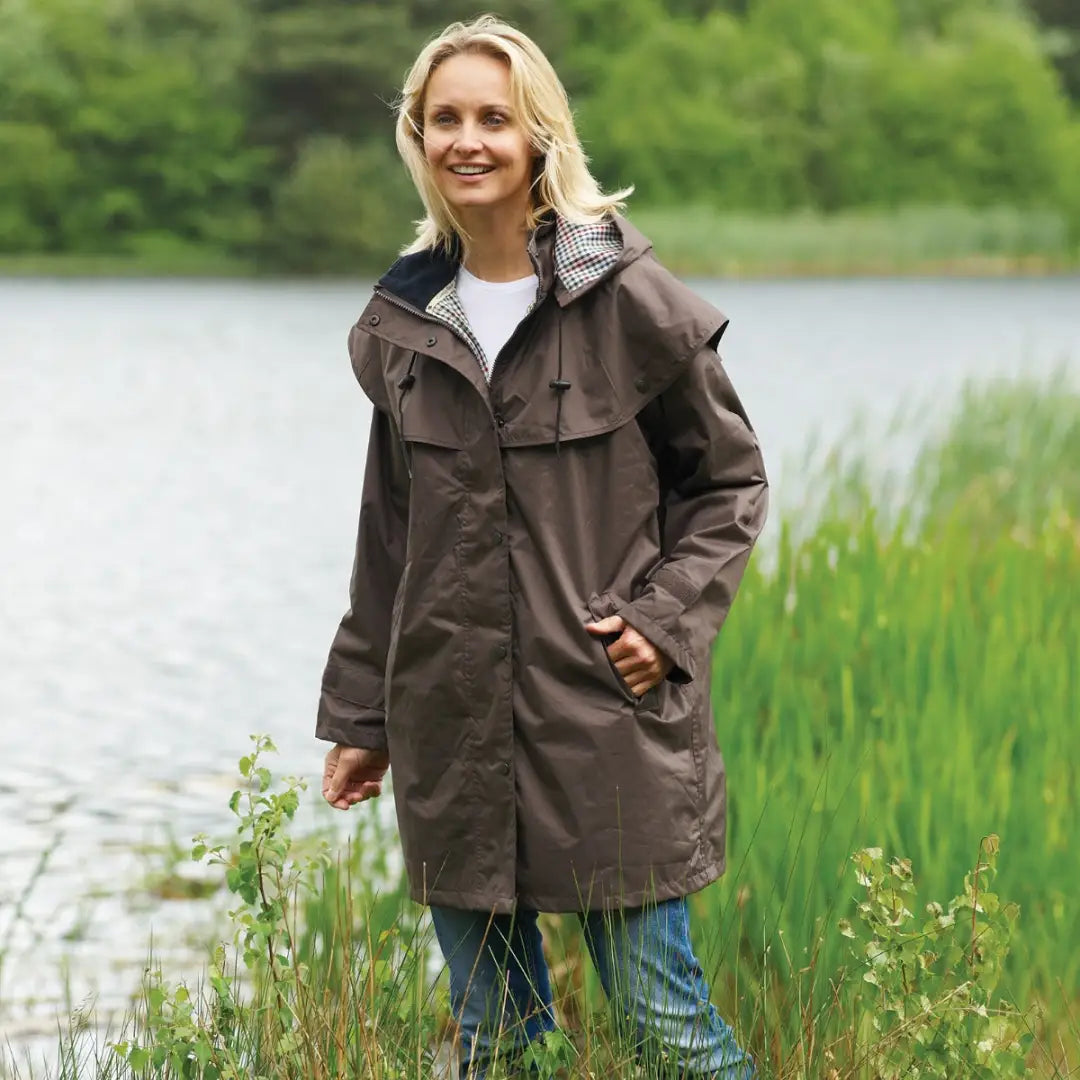 Person wearing a Brown Champion Windsor Riding Coat with hood for outdoor adventures