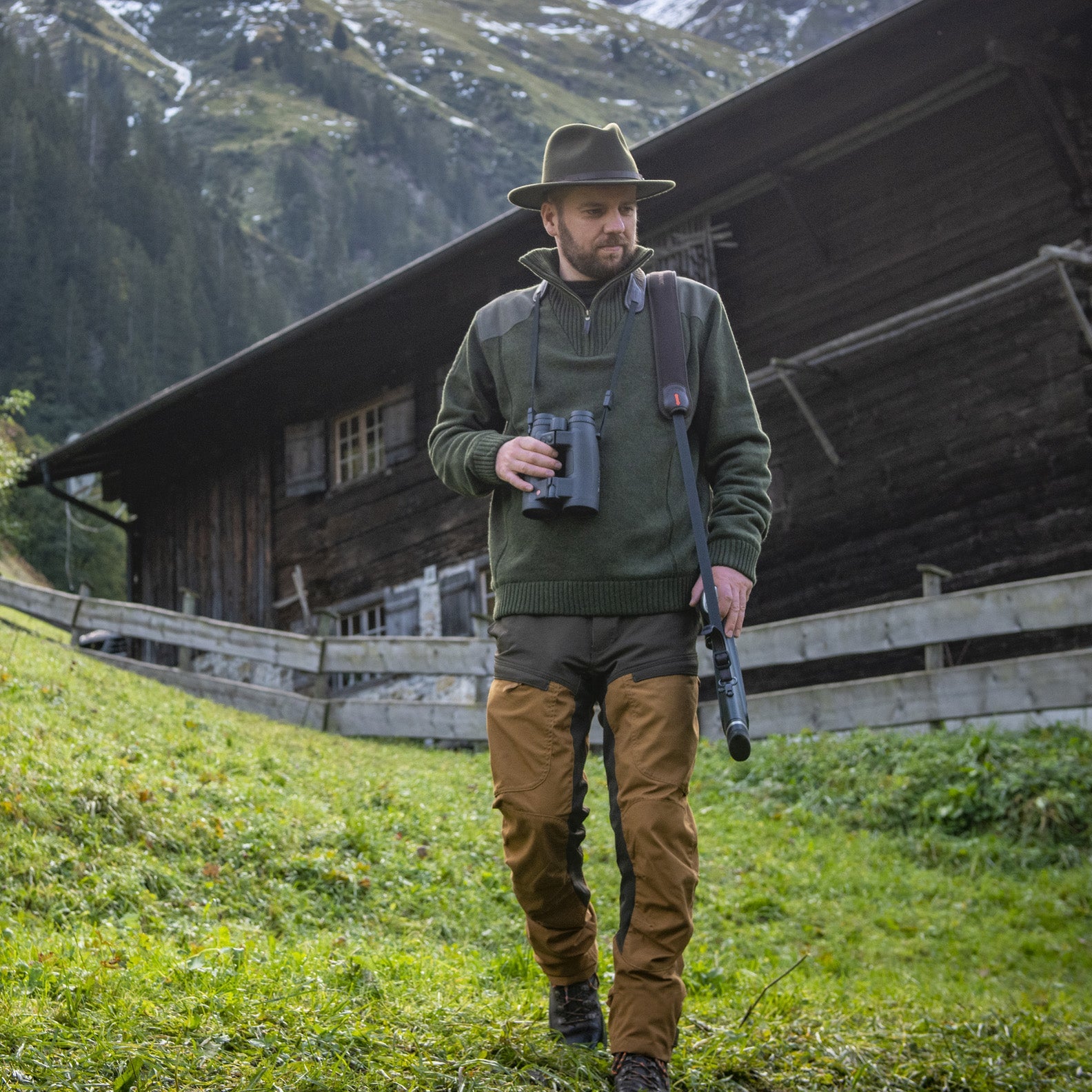 Hunter with rifle and binoculars wearing classic Carlisle Lambswool knit for warmth