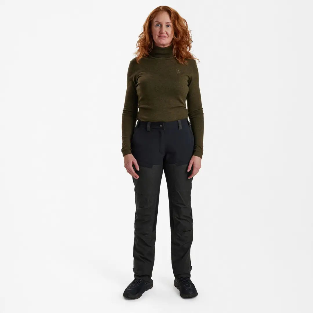 Woman with red curly hair in Deerhunter Lady Ann Trousers and dark green sweater