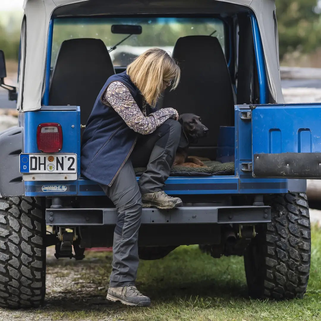 Blue off-road vehicle with a person climbing in, perfect for Deerhunter Lady Ann Trousers