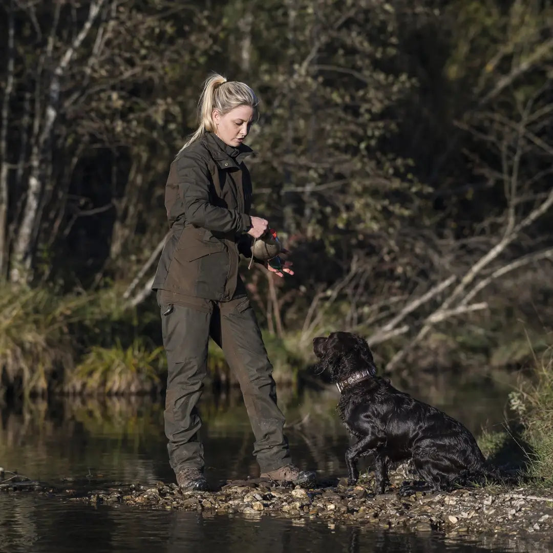 Woman in Deerhunter Lady Ann Trousers with her black dog by a lake