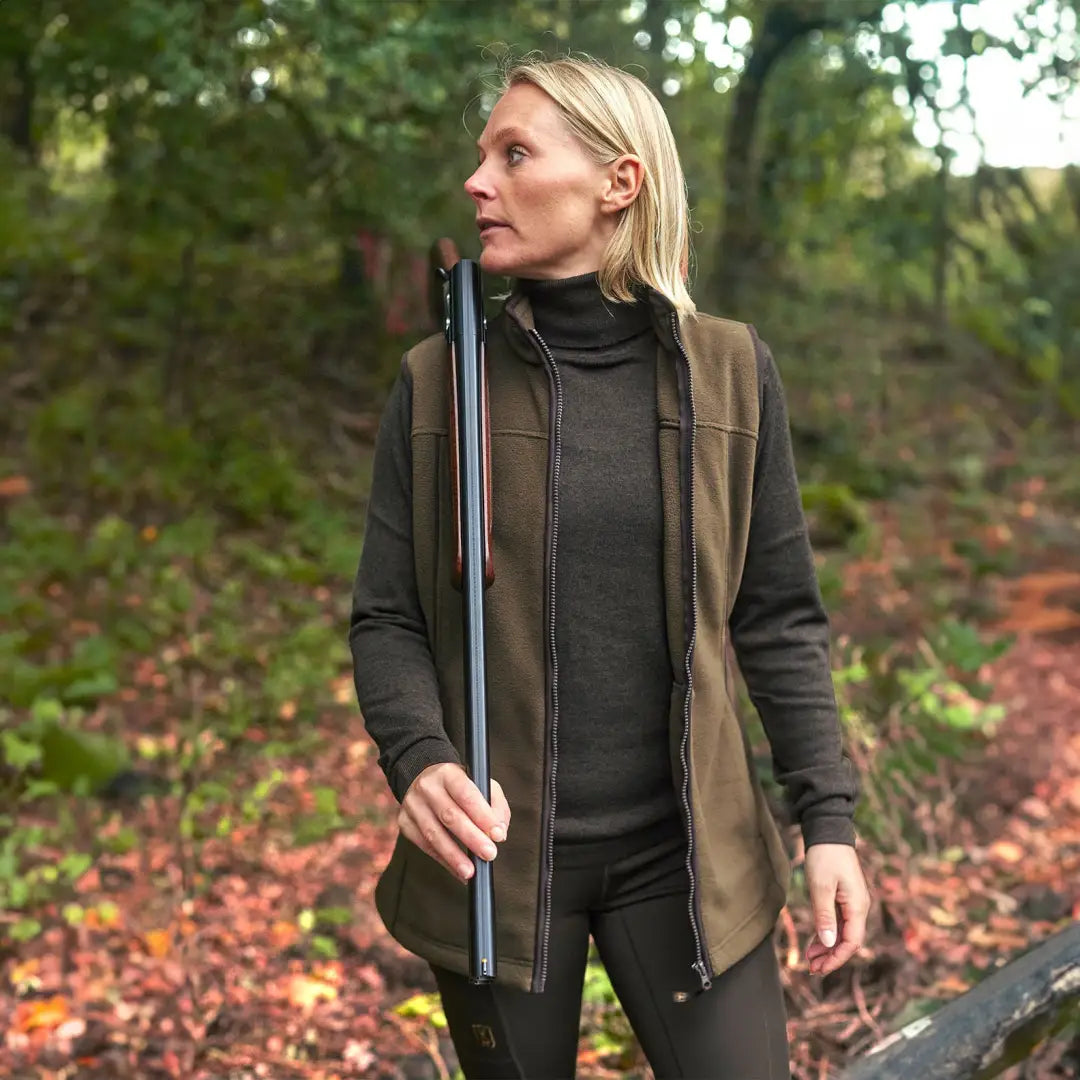 Woman in a Deerhunter Lady Eagle Fleece Waistcoat with a walking stick in the forest