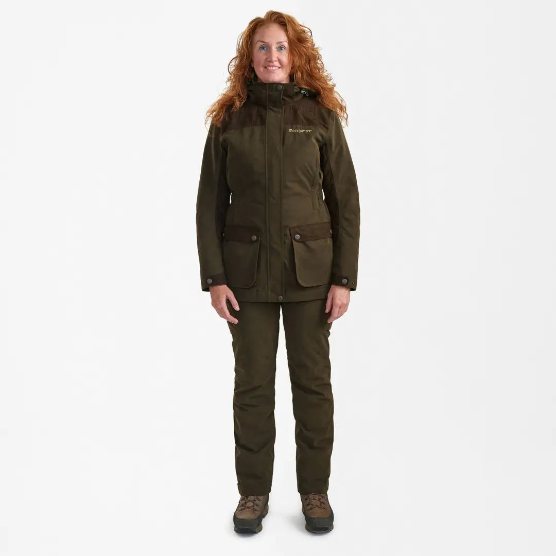 Woman in dark green Lady Eagle Jacket and matching pants for outdoor adventures