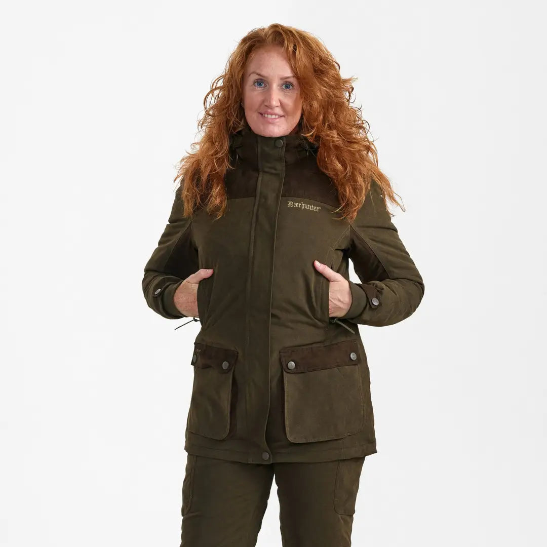 Woman with long curly red hair in a dark green Lady Eagle Winter Jacket