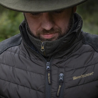 Person wearing Deerhunter Moor Padded Jacket with knitted sleeves and wide-brimmed hat