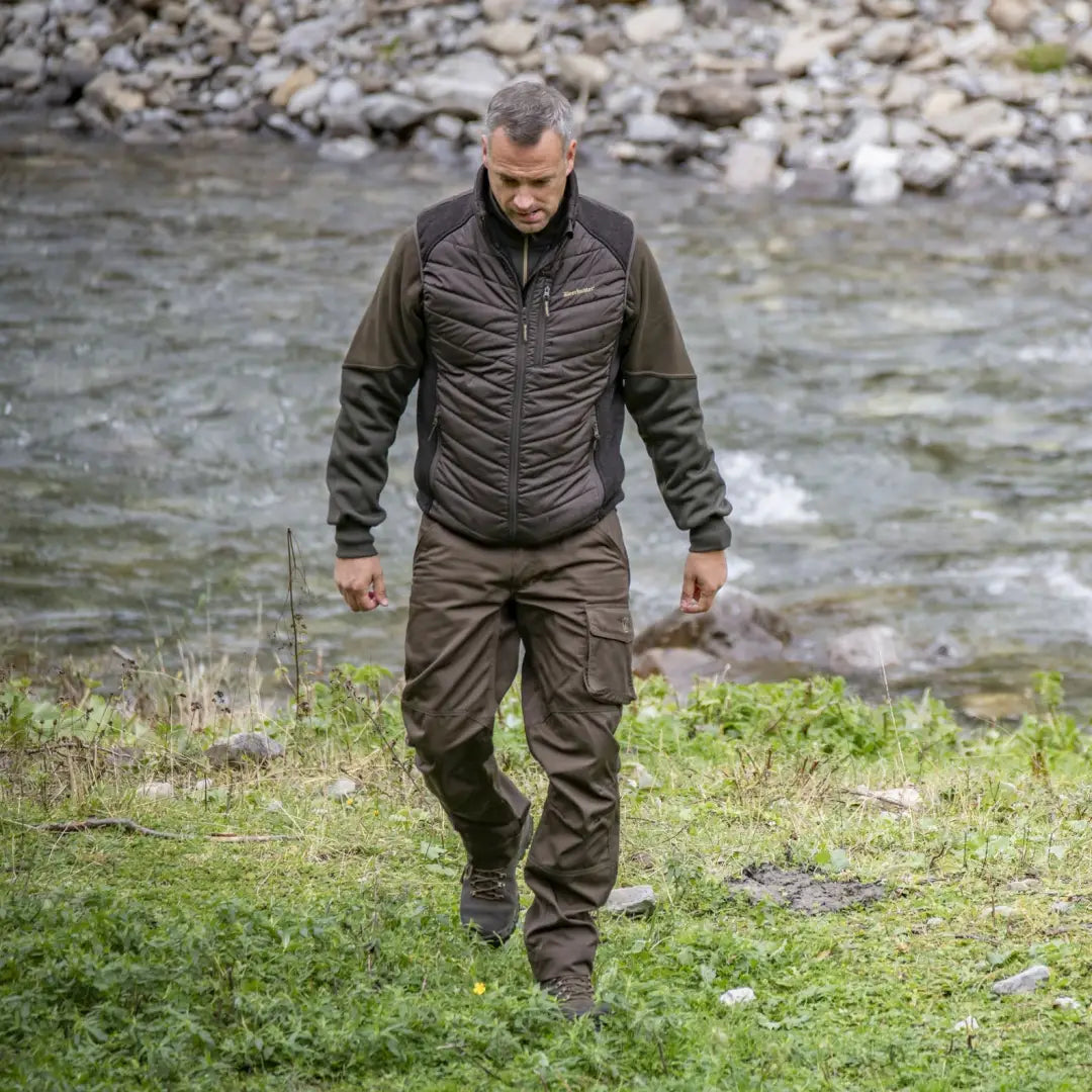 Man in Deerhunter Rogaland Trousers walking by a rocky stream in nature