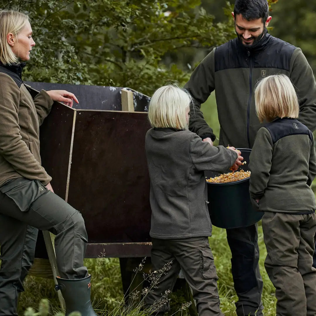 Family filling a compost bin while wearing Deerhunter Youth Eagle Trousers