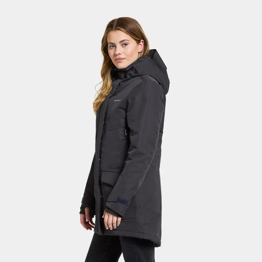 Dark gray hooded Didriksons Frida Womens Parka 7, fully windproof, on a blonde woman