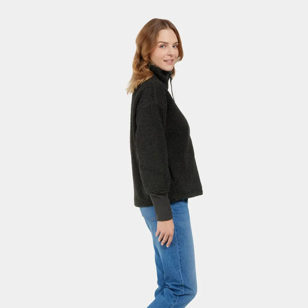 Woman in a black turtleneck sweater with blue jeans enjoys autumn’s crisp winds