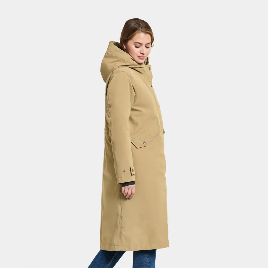 Long beige hooded winter coat worn by a person in Didriksons Mia Long Womens Parka