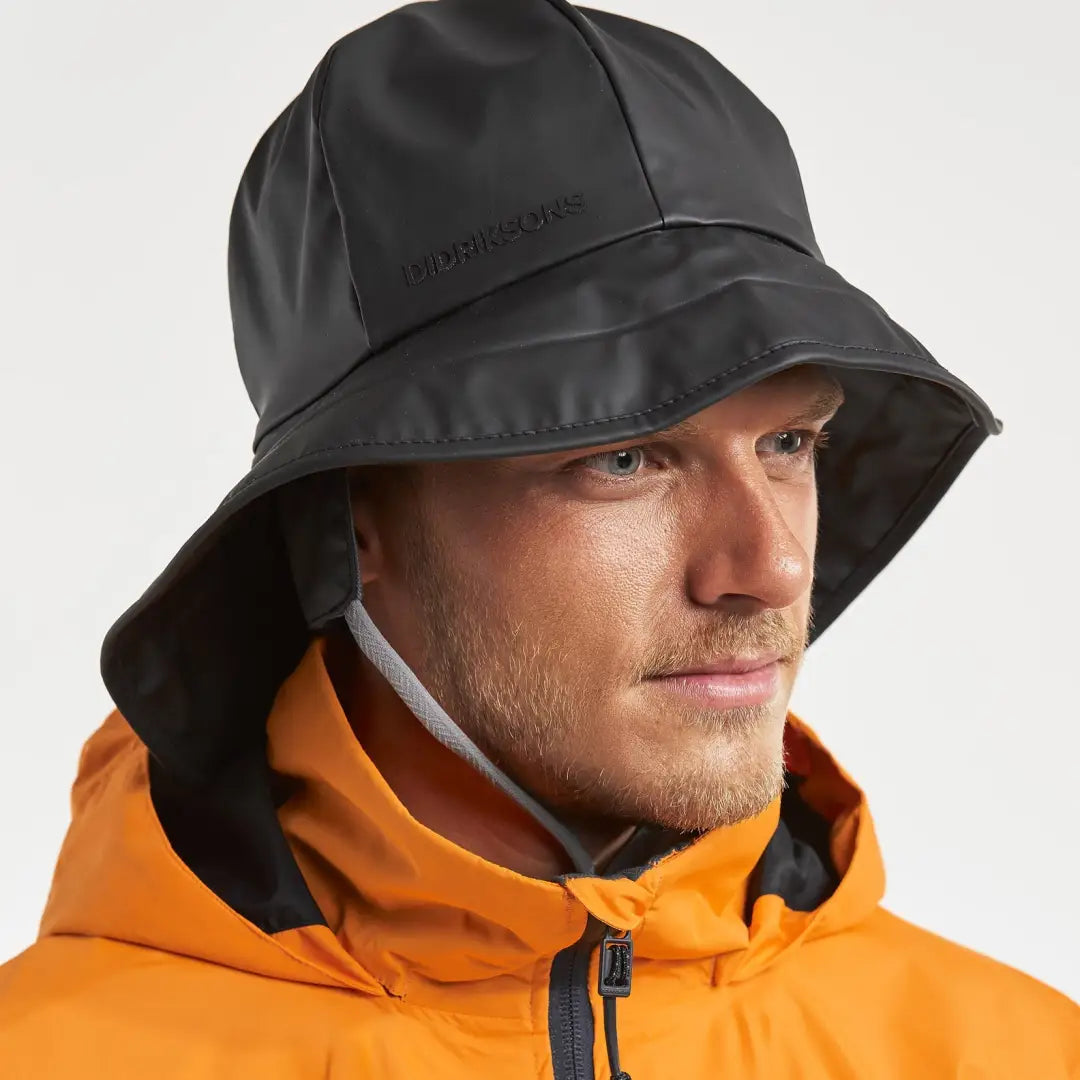 Person wearing a Didriksons Southwester Waterproof Rain Hat with an orange jacket