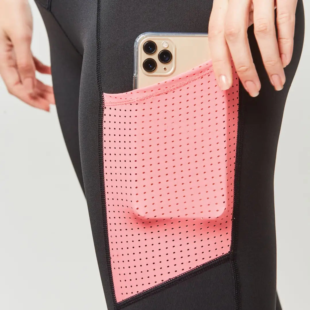 Pink perforated pocket on Dublin Power Performance tights holds a smartphone securely