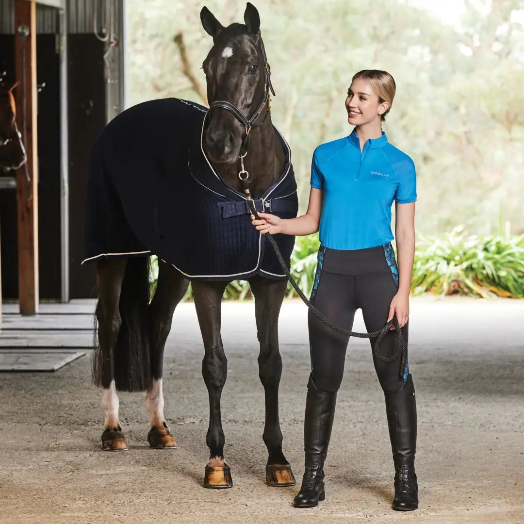 Dark brown horse in a navy blanket with a person wearing Dublin Sarah Short Sleeve Top