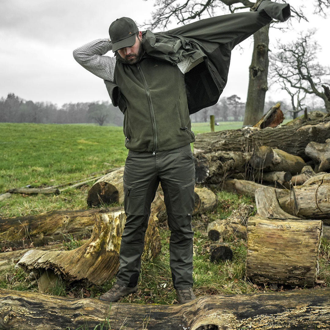 Man putting on a jacket with Harehill Ridgegate Trousers for a stylish utility look