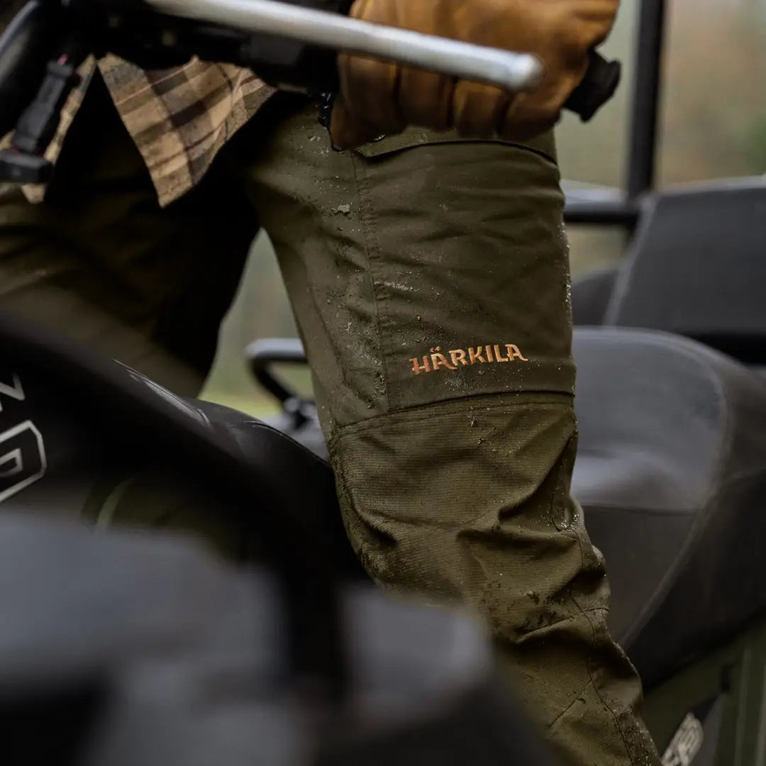 Olive green Harkila Asmund Trousers with logo, perfect for lightweight outdoor leisure