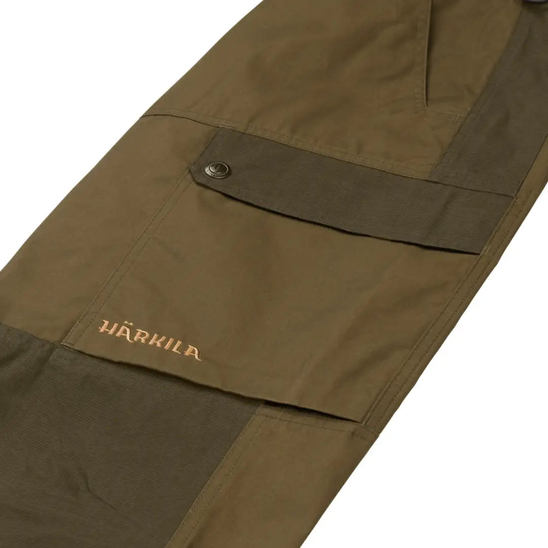 Olive green Harkila Asmund Trousers featuring a side pocket and waxed canvas material