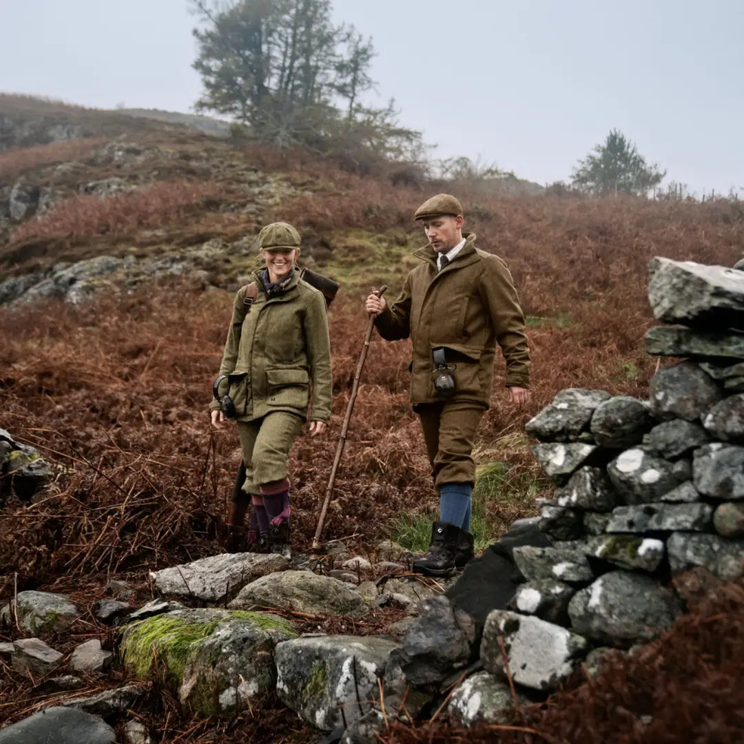 Two people in traditional attire exploring a rocky landscape in Kenmore GTX Jacket