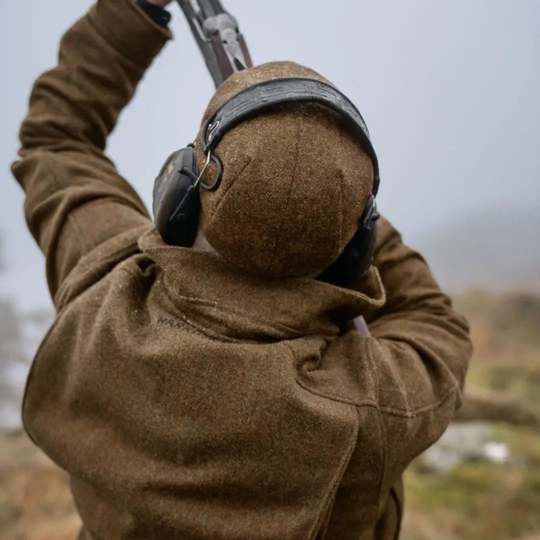 Headphones over a brown Harkila Kenmore GTX Jacket, blending traditional style and modern flair